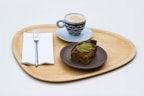 Elegant wooden tray holding coffee cups and pastries with natural wood grain visible