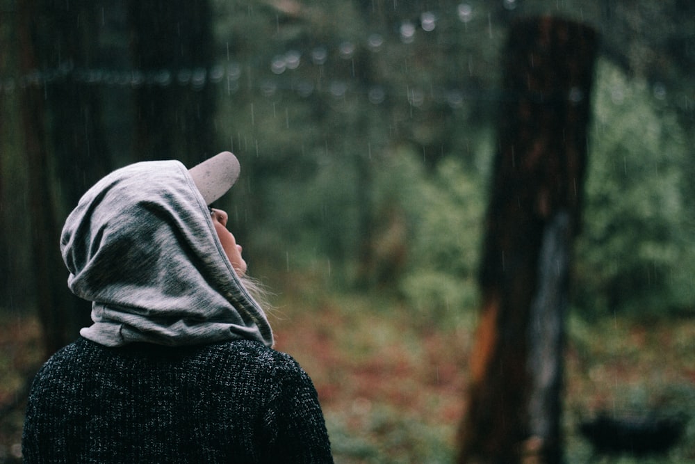 personne regardant les gouttes de pluie