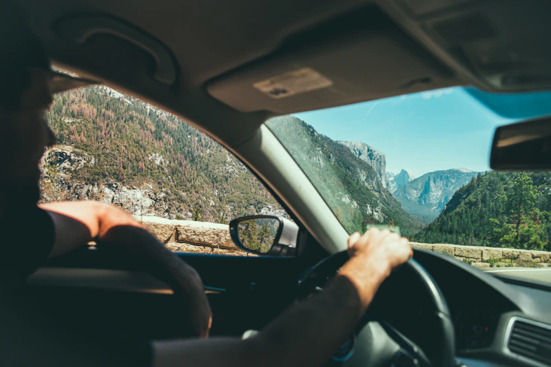 Joven feliz conduciendo por la ciudad
