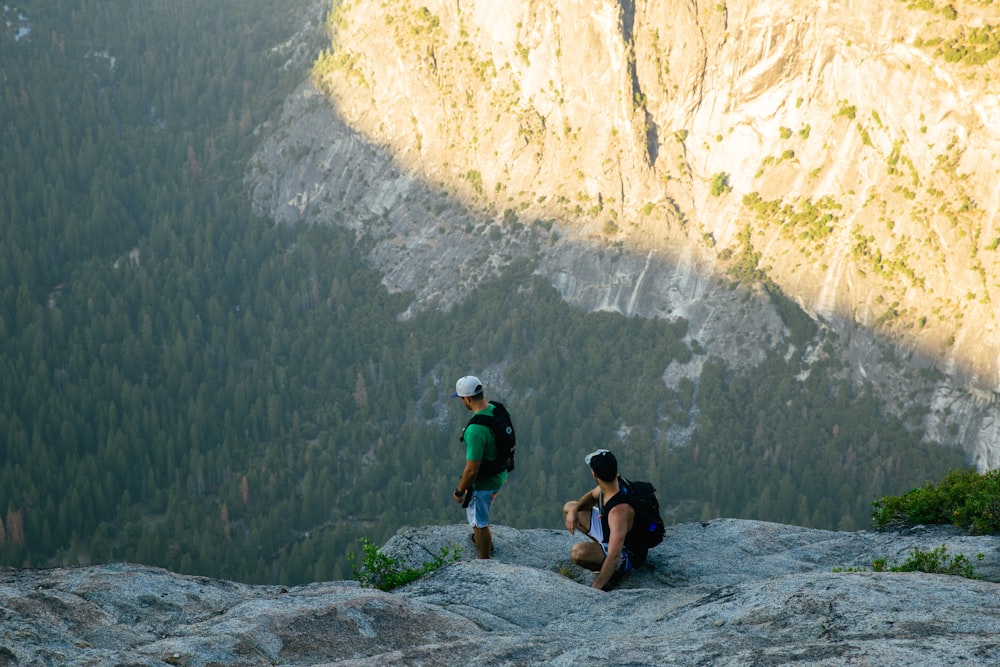 two men standing on rocky mountain cliff