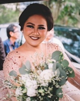 Abby smiling warmly backstage holding a bouquet of flowers after a performance