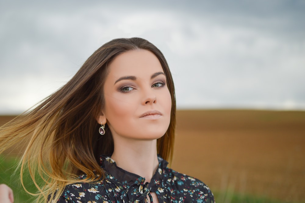 mulher usando top floral no campo durante o dia