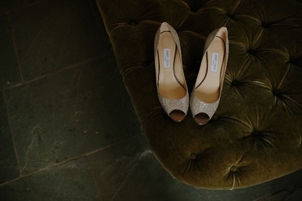 pair of brown gray leather open-toe heeled shoes on tufted mattress