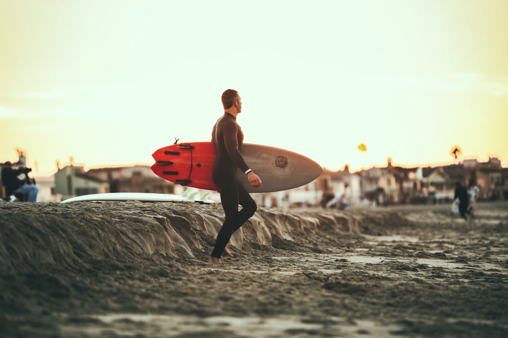 Persona que lleva una tabla de surf en el barro durante el día