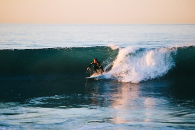 man surfing on ocean wave during daytime surfing google meet background