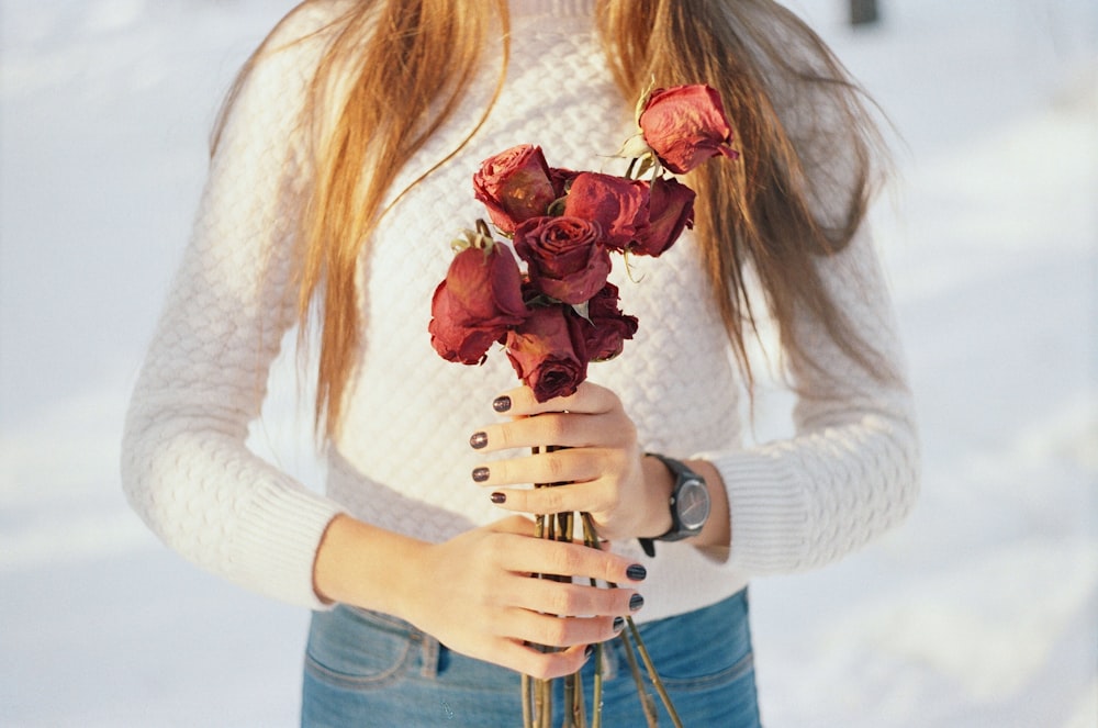 person holding bouquet of red roses