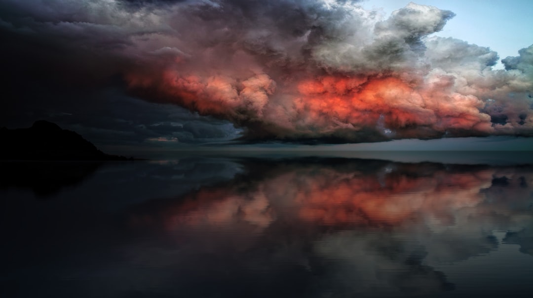 body of water under red and white clouds, Storm Approaching