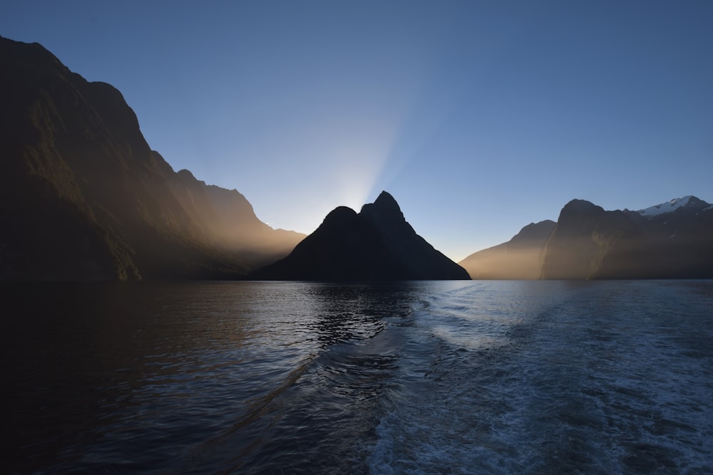 body of water near mountain under blue sky during day time