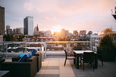 A rooftop restaurant setting with a view over the city, evoking fine rooftop dining