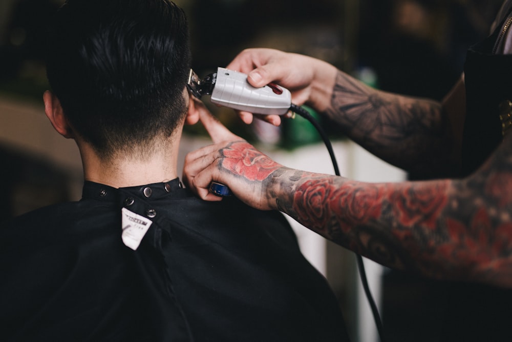 person using white hair clipper