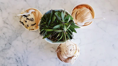 An artful arrangement of assorted ice cream tubs showcasing chocolate, vanilla, and pistachio flavors.