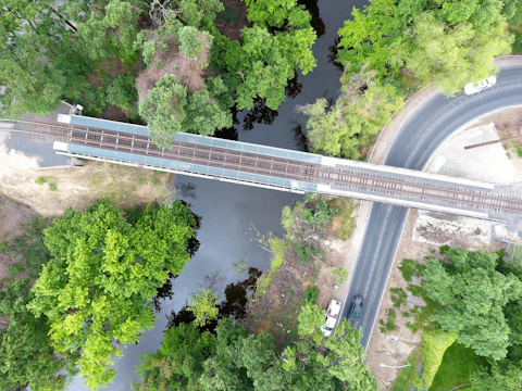 Wide view of a newly constructed railway bridge surrounded by lush greenery