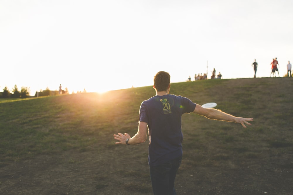 man walking on green grass field