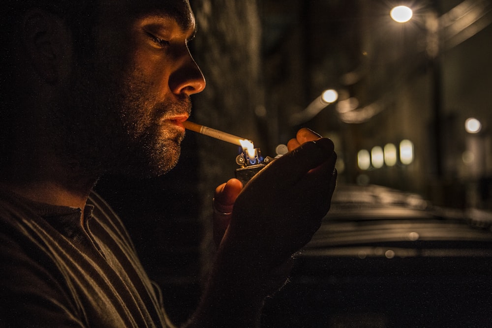 man lighting up flip-top lighter for cigar