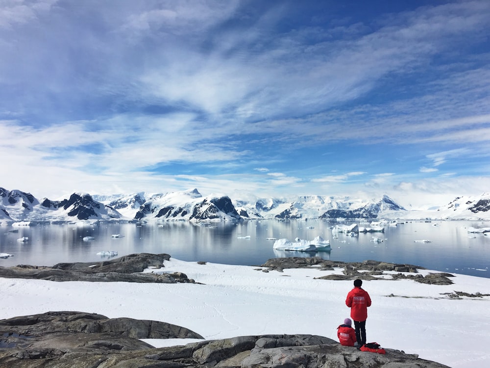 two person standing on snow field