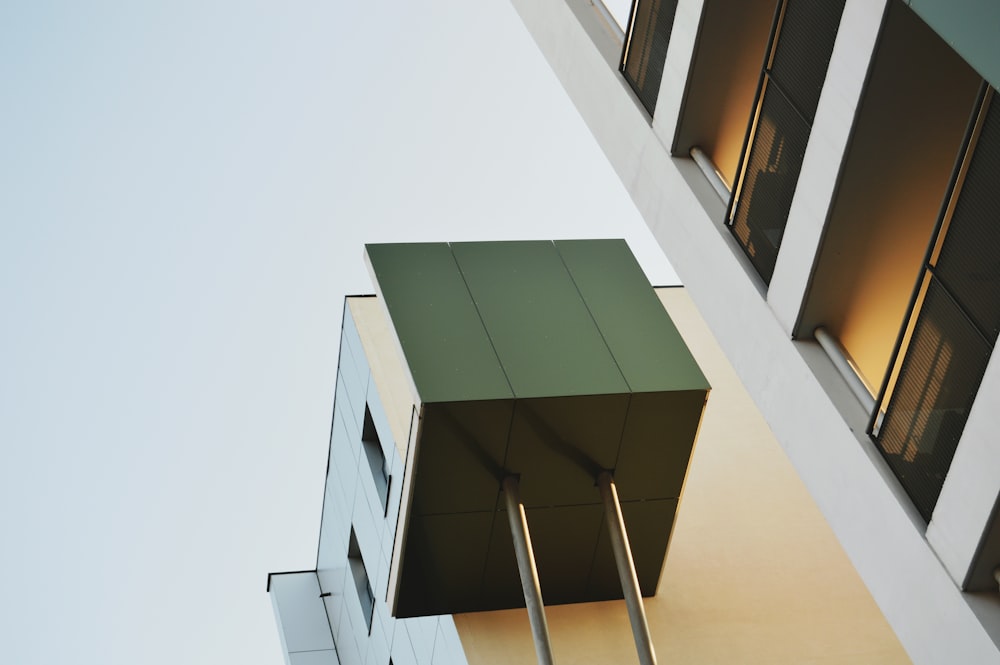 a tall building with windows and a green roof