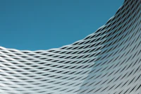 Curved white architecture with flowing lines against a blue sky