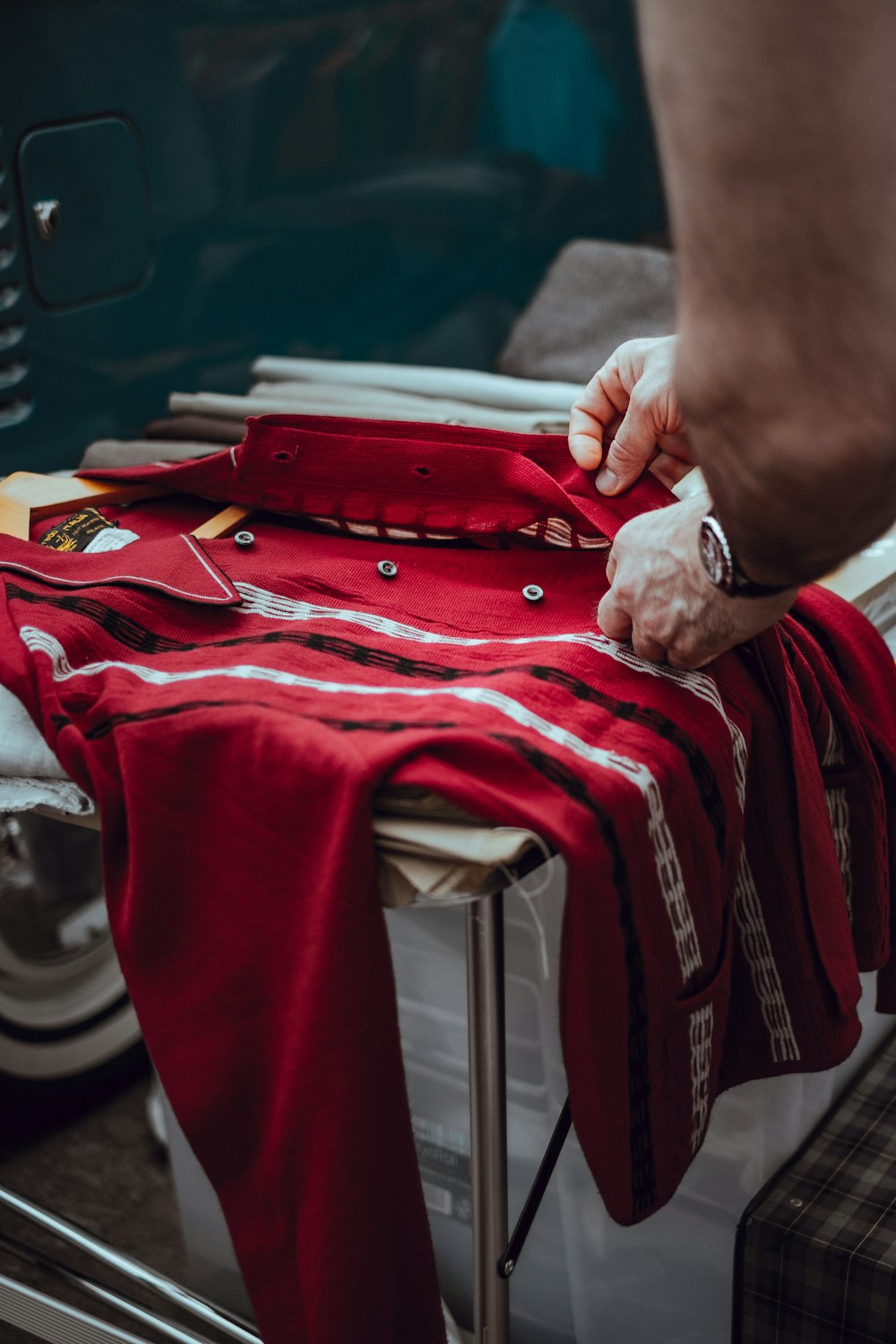 person holding red button-up dress shirt