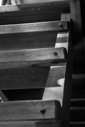 Detailed close-up of a handcrafted wooden staircase highlighting fine craftsmanship and rich wood tones.