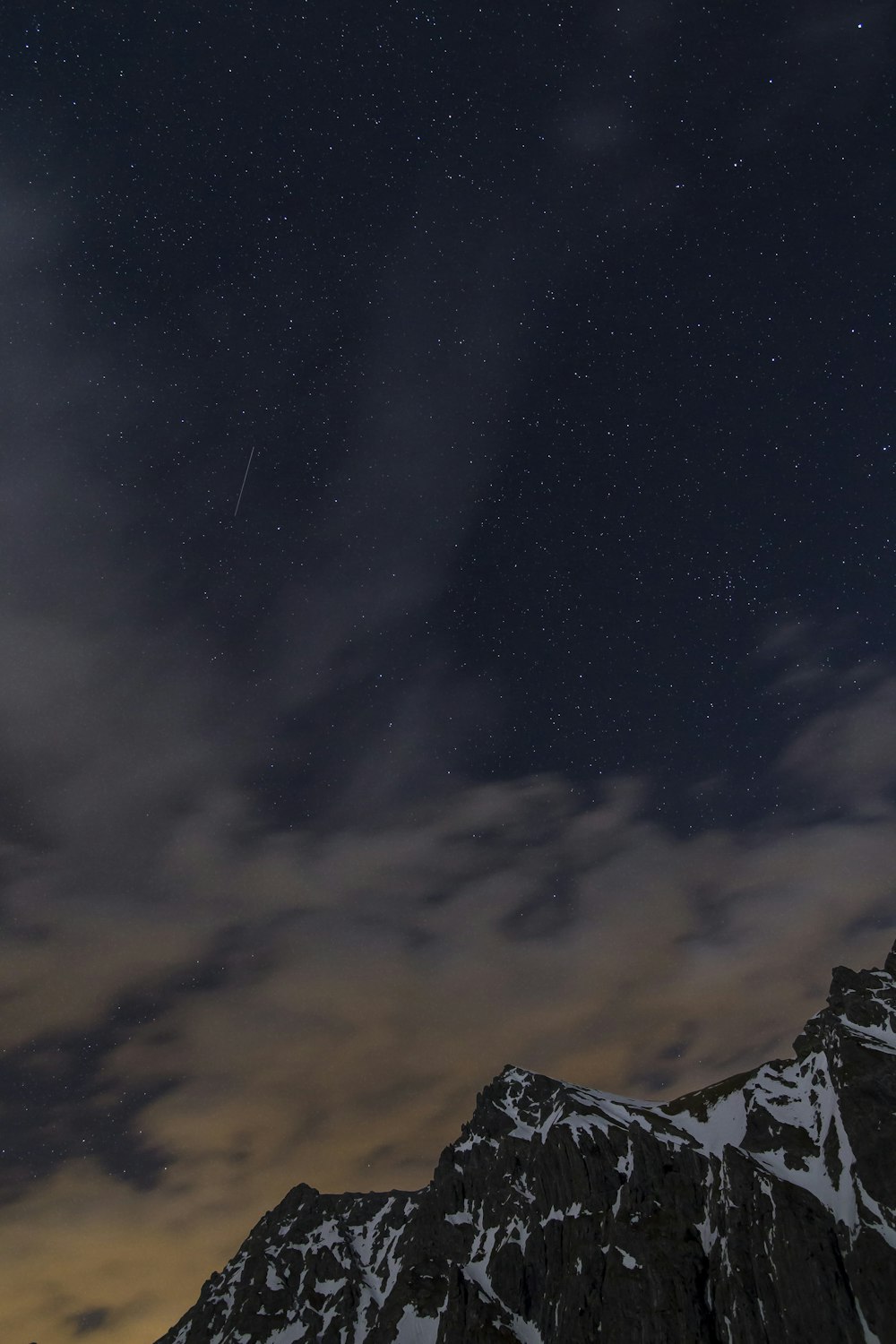 rocky mountain under dim cloudy sky