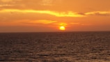 A vibrant sunset over a tranquil ocean horizon.