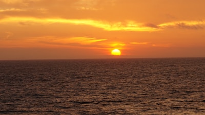 A vibrant sunset over a tranquil ocean horizon.