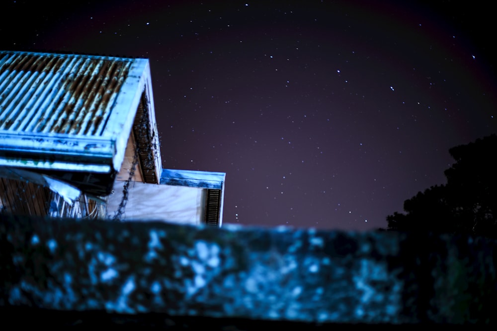 a building with a rusty roof under a night sky