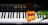 A piano keyboard with the brand name 'Hobart M. Cable' is adorned by vibrant orange tulips placed on the keys, creating a striking contrast between the dark and light elements.