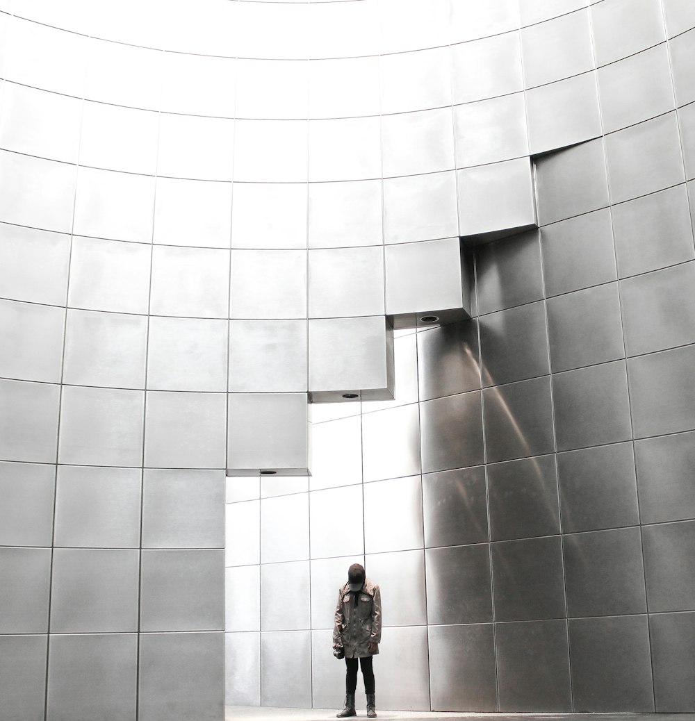 Persona in piedi sotto l'edificio del blocco di metallo