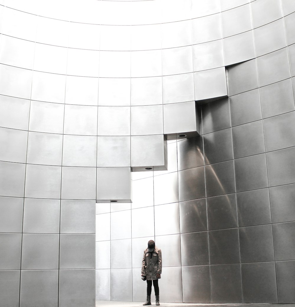 personne debout sous le bâtiment en blocs métalliques