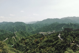 A serene landscape of the Great Wall winding through lush mountains.