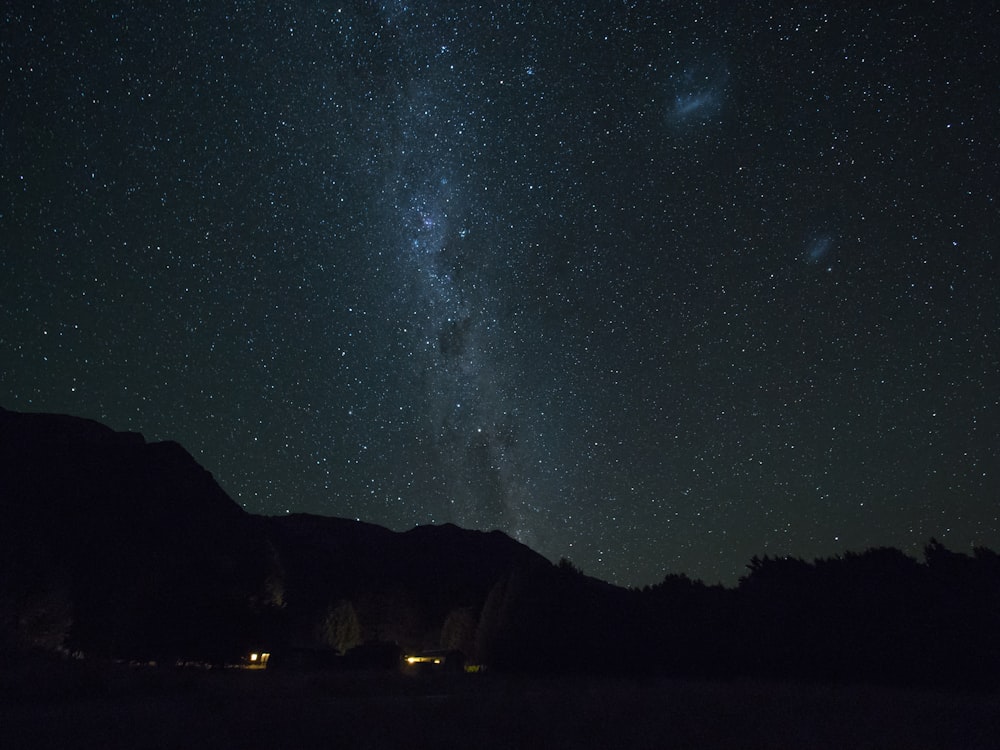 mountains and sky full of stars during night