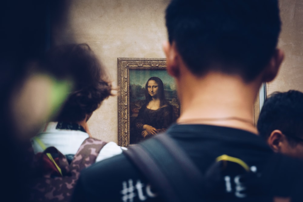 homens na frente da pintura de Mona Lisa
