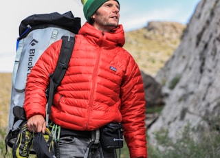 man looking above carrying gray camping backpack