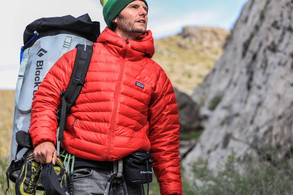 hombre mirando hacia arriba llevando mochila gris para acampar