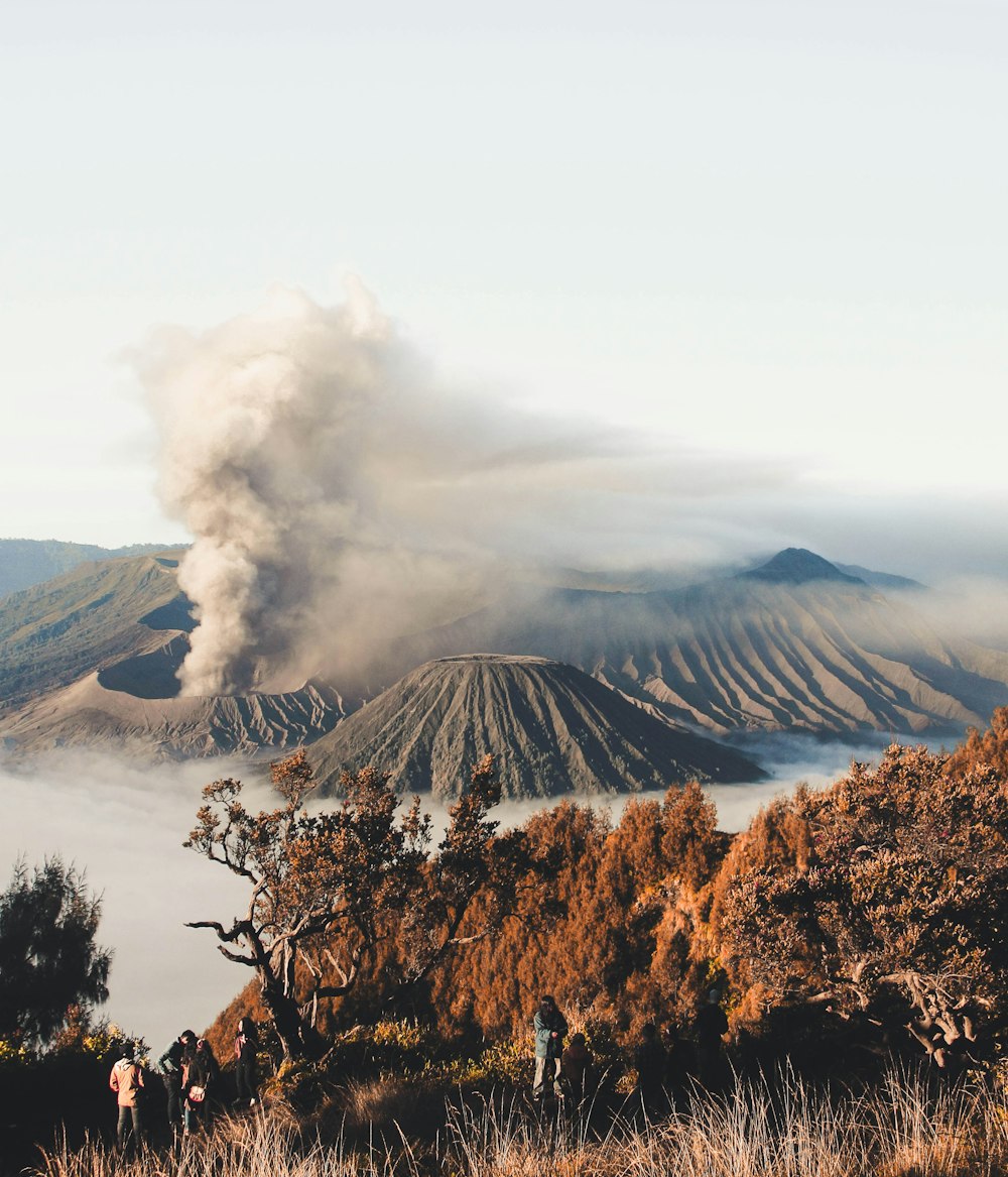 person standing on cliff with volcano background