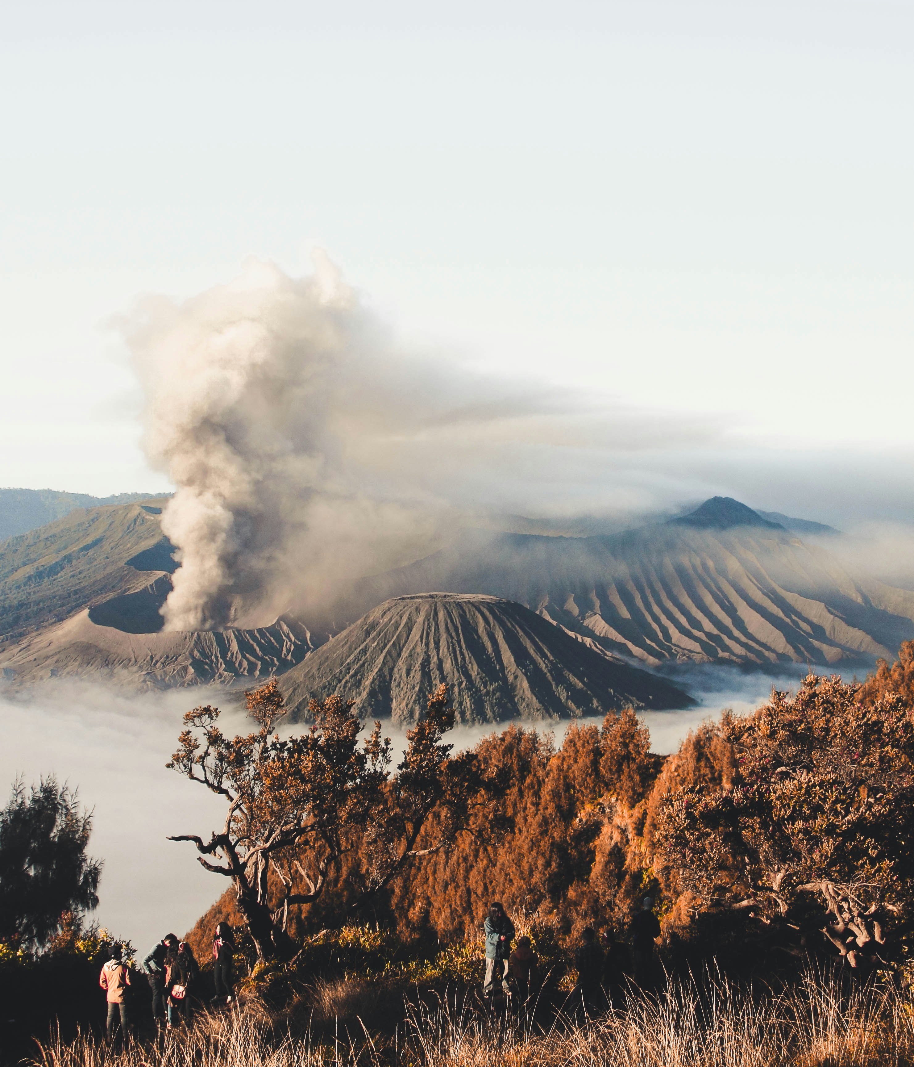 person standing on cliff with volcano background