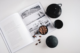 selective color photo of teapot and teacup on book