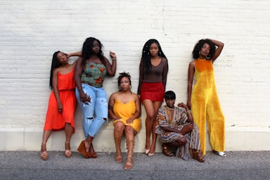 photography poses for big groups,how to photograph reflecting queens; six women leaning on white wall