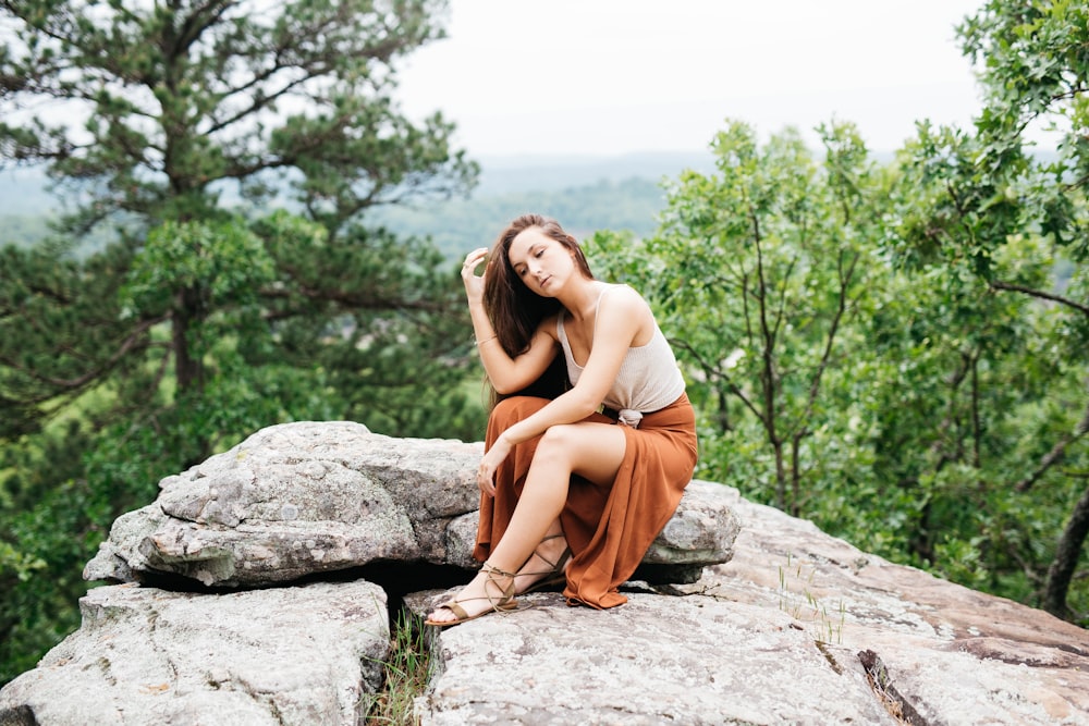 woman sitting on rock during daytime