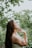 A woman reflecting peacefully in a serene outdoor setting.