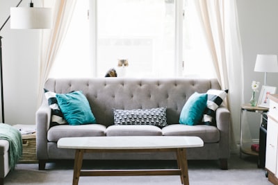 brown and white wooden table beside sofa chair decor teams background