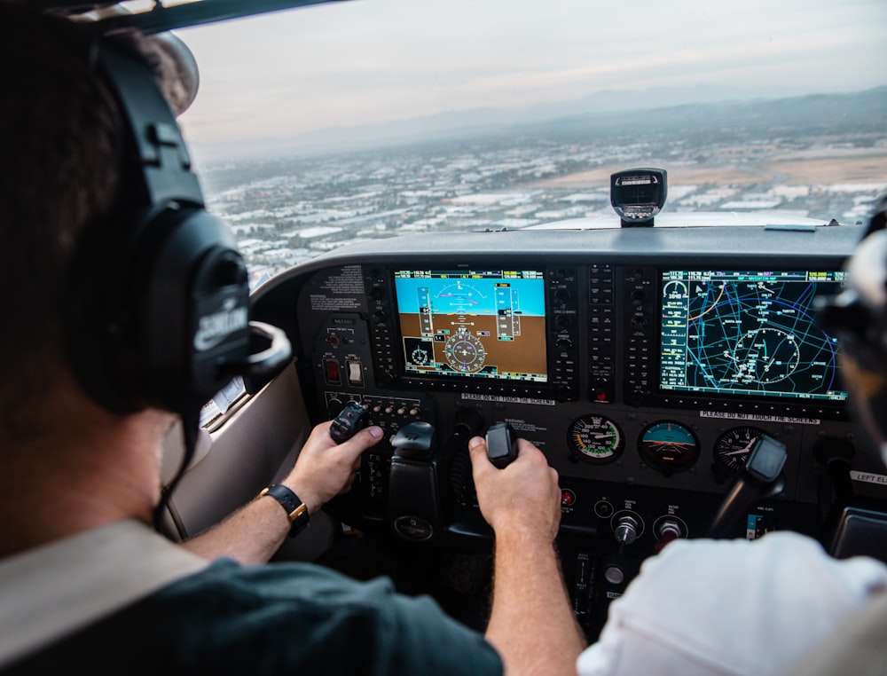 man flying aircraft under cloudy sky