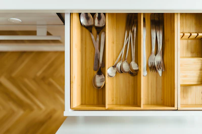 A sleek, modern kitchen drawer organizer with neatly arranged utensils and spices.