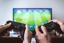 two people playing Sony PS4 game console