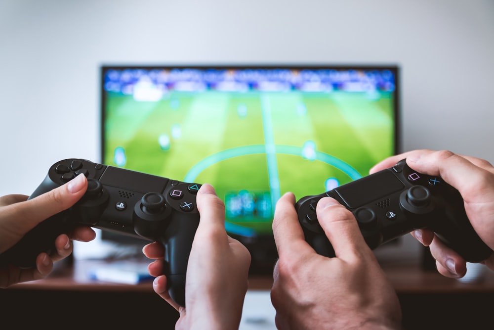 Premium Photo  Close up of gamer holding controller to play video games in  front of computer. player using joystick and playing online games on  monitor, sitting at desk. man gaming with