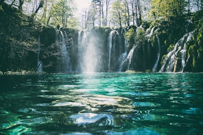 time-lapse photography of flowing multi-tier waterfall waterfall teams background