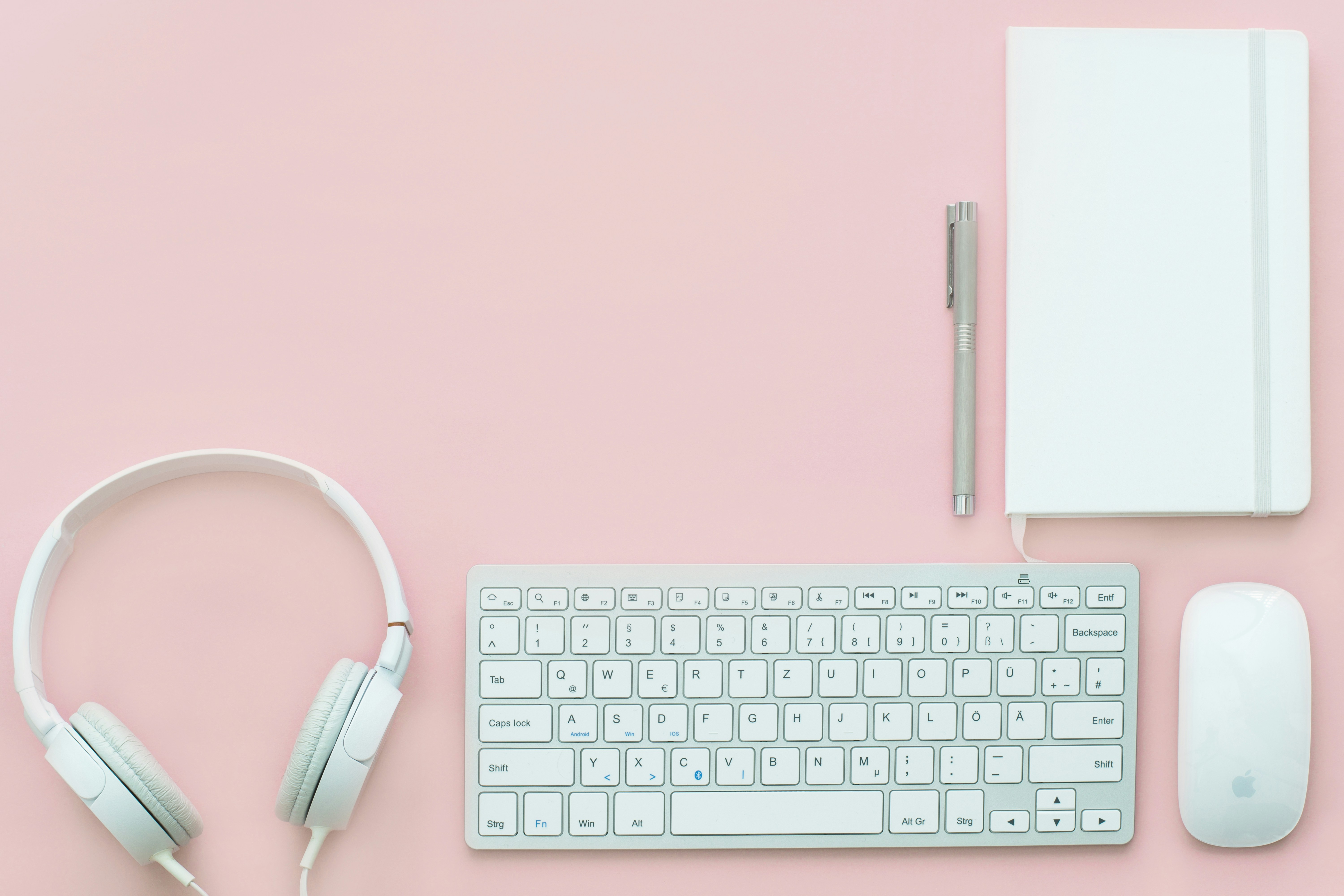 Branimo workspace setup with white Apple Magic Mouse, Magic Keyboard, and headphones.