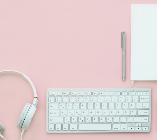 white Apple Magic Mouse beside of Magic Keyboard and headphones