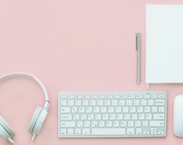 white Apple Magic Mouse beside of Magic Keyboard and headphones